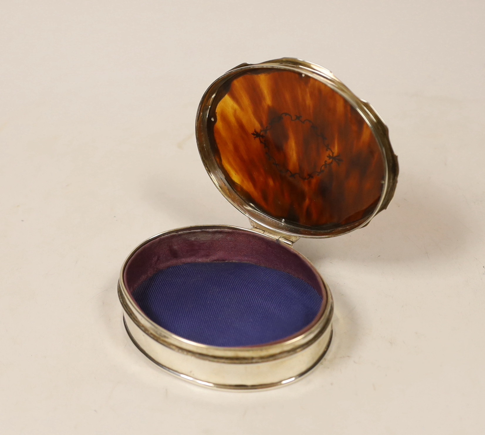 A George V silver and tortoiseshell mounted shaped oval trinket box, by Goldsmiths & Silversmiths Co Ltd, London, 1927, 98mm.